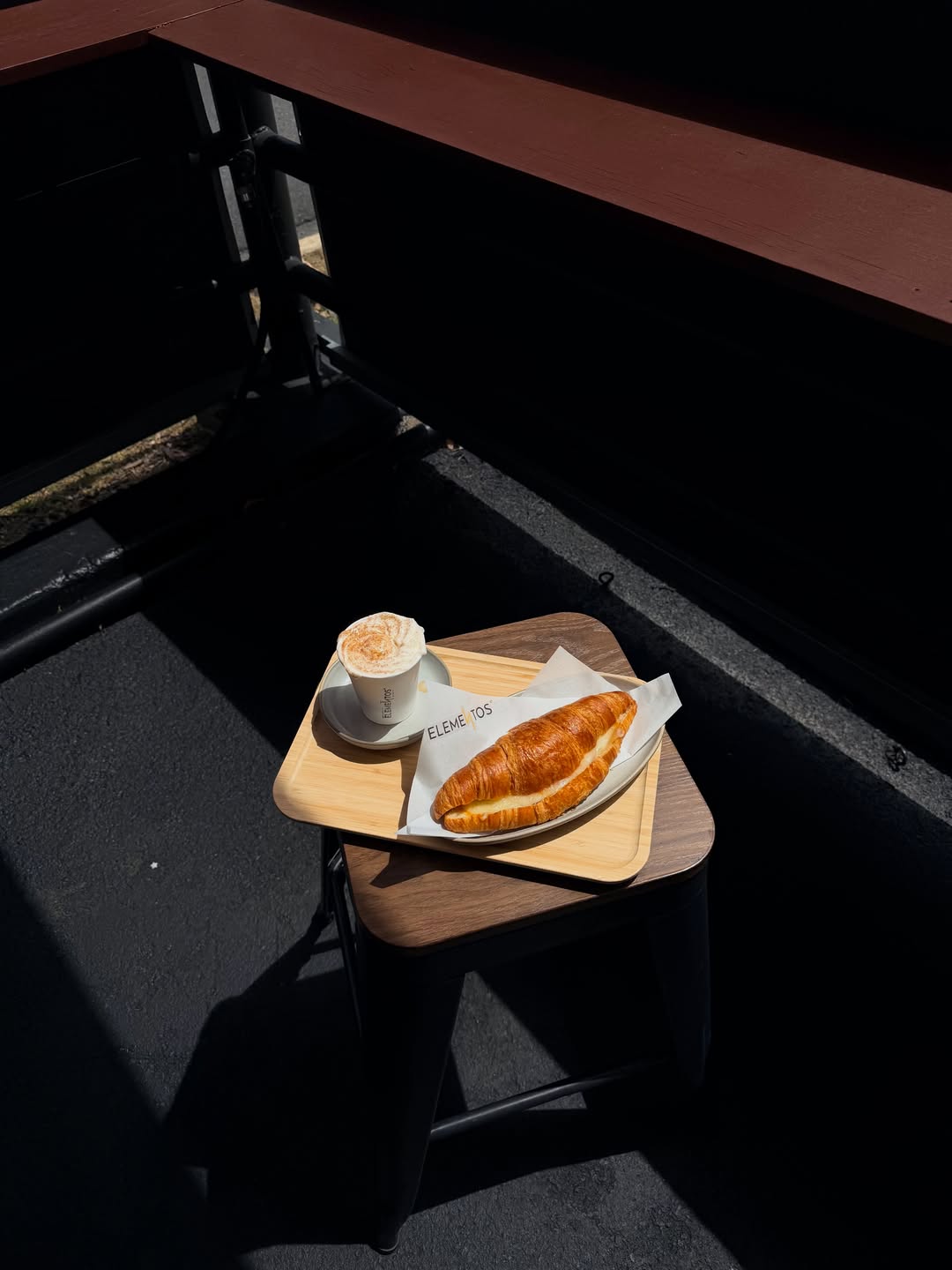 Café y croissant de Elementos sobre una bandeja